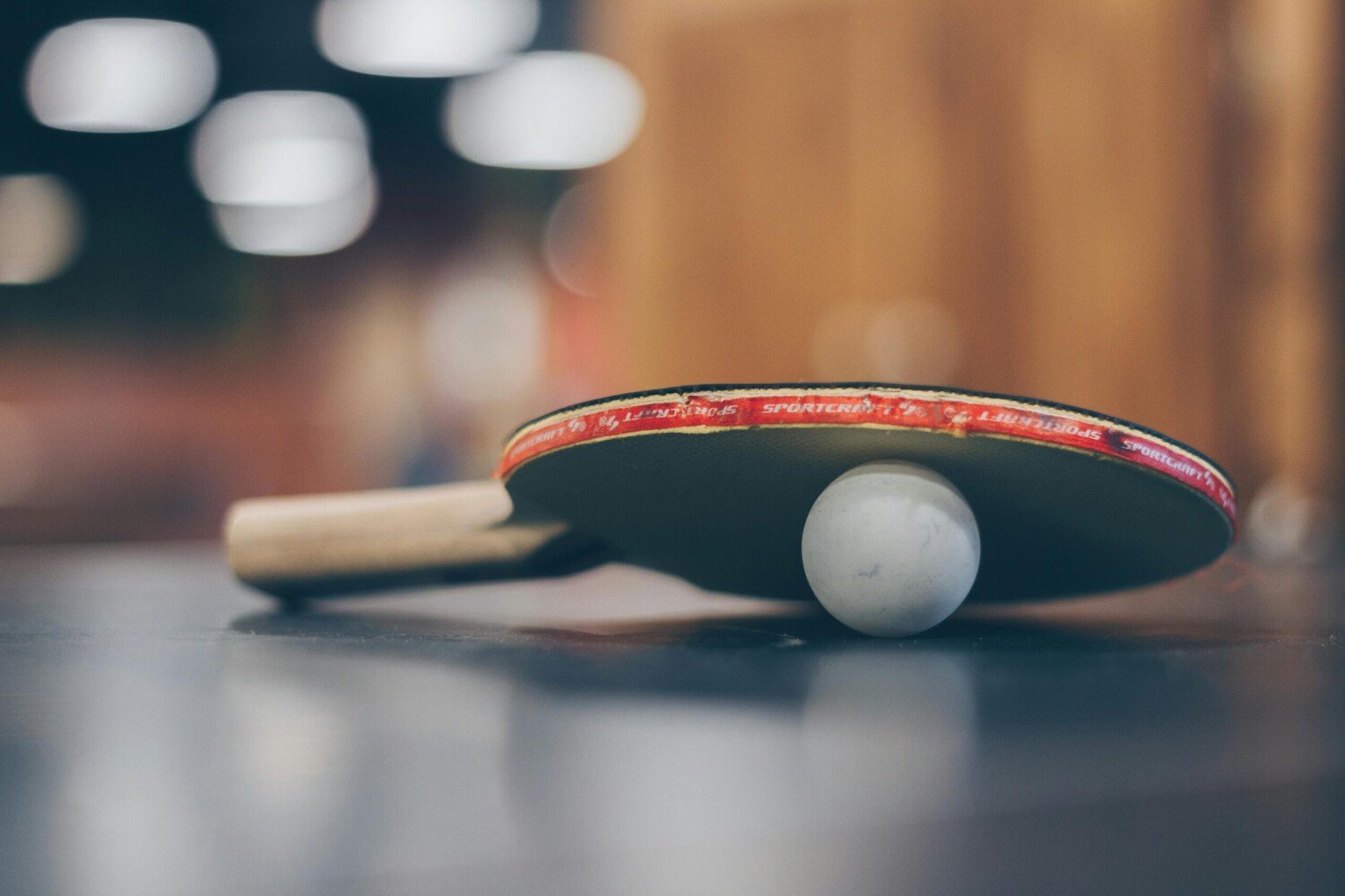 Tauche ein in die Welt des Tischtennis – spannende Runden warten auf dich! Tischtenniskelle mit Ball auf einem Tisch – bereit für actionreiche Matches.